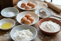 Baking ingredients with eggs flour whisk on rustic kitchen table Royalty Free Stock Photo