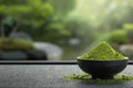 A black bowl filled with vibrant green matcha powder is placed on a textured mat Royalty Free Stock Photo