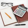 Calculator, notebooks, pens, and glasses arranged. Royalty Free Stock Photo