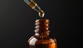A dropper dispenses a single drop of liquid into an amber glass bottle on a dark background Royalty Free Stock Photo