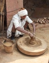 Untouchable Caste Indian Man at Pottery Wheel with Many Pots Royalty Free Stock Photo