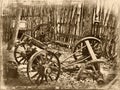 Aged image of an old 19th century western junk yard with broke down buck board and stage coach