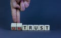 Untrust or trust symbol. Businessman turns wooden cubes, changes words `untrust` to `trust`. Beautiful grey table, grey backgr Royalty Free Stock Photo