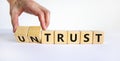 Untrust or trust symbol. Businessman turns wooden cubes, changes words `untrust` to `trust`. Beautiful white table, white Royalty Free Stock Photo