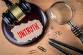 UNTRUTH. Law, regulations and judgment concept. Judge`s hammer, stationery and magnifying glass Royalty Free Stock Photo