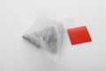 Unused pyramid tea bag with tag on white. Space for text Royalty Free Stock Photo