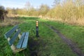 An unused rest bench along a walking path in Balijbos with a direction indicator