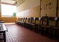 Unused student chair in front of the broken door of an old classroom