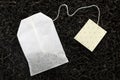 Unused tea bag with tag on dry leaves, top view. Royalty Free Stock Photo