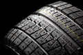 Unused winter car tire on a black background. Royalty Free Stock Photo