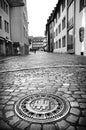 Black and white city street view with beautiful carved manhole, Freiburg im Breisgau, Germany