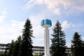 Unusual clock on a background of a white-blue sky. A clock in the form of a molecule, an atom. chemical production, a watch-column