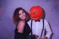 Unusual couple at Halloween party, Woman with pumpkin on head