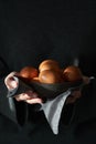 Unusual Easter on a dark background. A bowl of brown eggs with hands Royalty Free Stock Photo