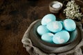 Unusual Easter on dark old background. Ceramic brown bowl with blue eggs