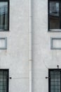 An unusual facade of an office building. Narrow non-standard windows form an amazing recognizable style. A drainpipe spoils the