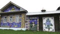 Unusual facade an old wooden house decorated by colorful mosaic pictures from small plastic bottle caps, creativity