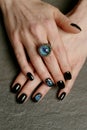 Unusual fantasy nail art and ring on manicured hands close-up