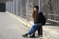 Unusual girl with dreadlocks in a black hat and in a black coat