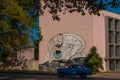 Unusual graffiti on the house, drawing on the wall: The man leaned over with the bitten globe in his hand. Havana. Cuba