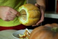 Unusual Halloween melon, cutting process, seeds and leftovers on the kitchen table