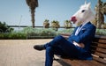 Unusual manager in elegant suit sits on the bench on the city street