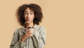 Unusual offer, think about it and choice. Pensive african american female, holds cup of coffee