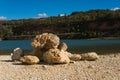 Unusual pile of large stones on the shore of the lake on a sunny day
