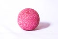 Unusual pink ball ball made of small particles with shadow