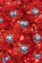 An unusual red Christmas tree. The Christmas tree is decorated with disco balls. Concept of style. Trend. Courage and