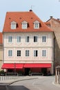 Unusual renovated old apartment building with decorative frames around windows and new roof tiles next to paved road Royalty Free Stock Photo