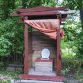 Unusual rustic wooden toilet in the form of a pagoda without door