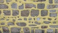 Unusual stone wall with yellow painted cement background texture Royalty Free Stock Photo