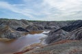 Unusual surreal alien blur landscape. The river is surrounded by gray clay hills against a bright blue sky