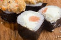 Unusual sushi rolls on a wooden table. Ukrainian sushi rolls with baked cheese and crabs