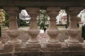 Unusual view through columns at gorgeous bride and stylish groom walking at old castle in european park in autumn time. happy Royalty Free Stock Photo