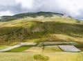 Unusual view featuring green and white. Rocky mountain and fields in the valley, Castelluccio di Norcia, in Umbria