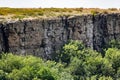 An unusual view in the Rostov region of the stony Zaitsev rocks, around green deciduous trees, dry yellow grass,