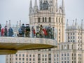 An unusual view of the Soaring Bridge in Zaryadye Park. Close-up of tourists on the Floating Bridge against the backdrop