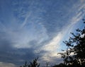 Unusual white clouds and birds on a blue sky during sunset