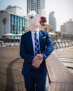 Unusual young man in elegant suit stands on the city waterfront