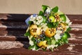 An unusually beautiful bouquet of flowers and fruits lies on a bench