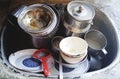 Unwashed kitchen utensils in the wash basin need to be cleaned and washed, a pile of dirty dishes, bows, pots and mug Royalty Free Stock Photo