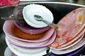 Unwashed kitchen utensils in the wash basin need to be cleaned and washed, a pile of dirty dishes, knives, pots and drinking glass Royalty Free Stock Photo