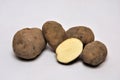 Whole and sliced unwashed potatoes on a seamless background