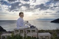 Unwavering Confidence: A Handsome Boy Poses on the Cliff at Sunset