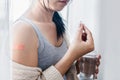 Unwell woman taking paracetamol medicine after getting vaccinated for anti coronavirus, covid-19 Royalty Free Stock Photo