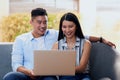 Unwinding in the new age. Shot of a happy young couple using a laptop together on the sofa at home. Royalty Free Stock Photo