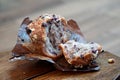 Unwrapped and broken blueberry muffin on brown wax paper on a brown wood table Royalty Free Stock Photo