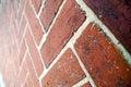 Angled perspective view of diagonal herringbone red brick wall background